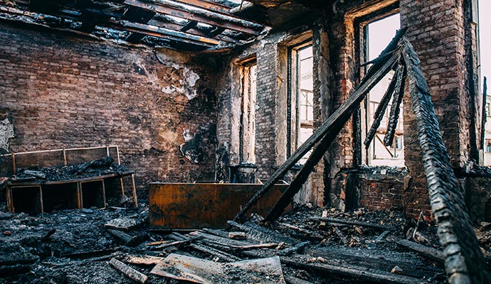 fire damage restoration burnt room interior with walls furniture and floor in ash and coal